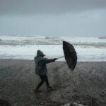 unrecognizable person with umbrella on beach